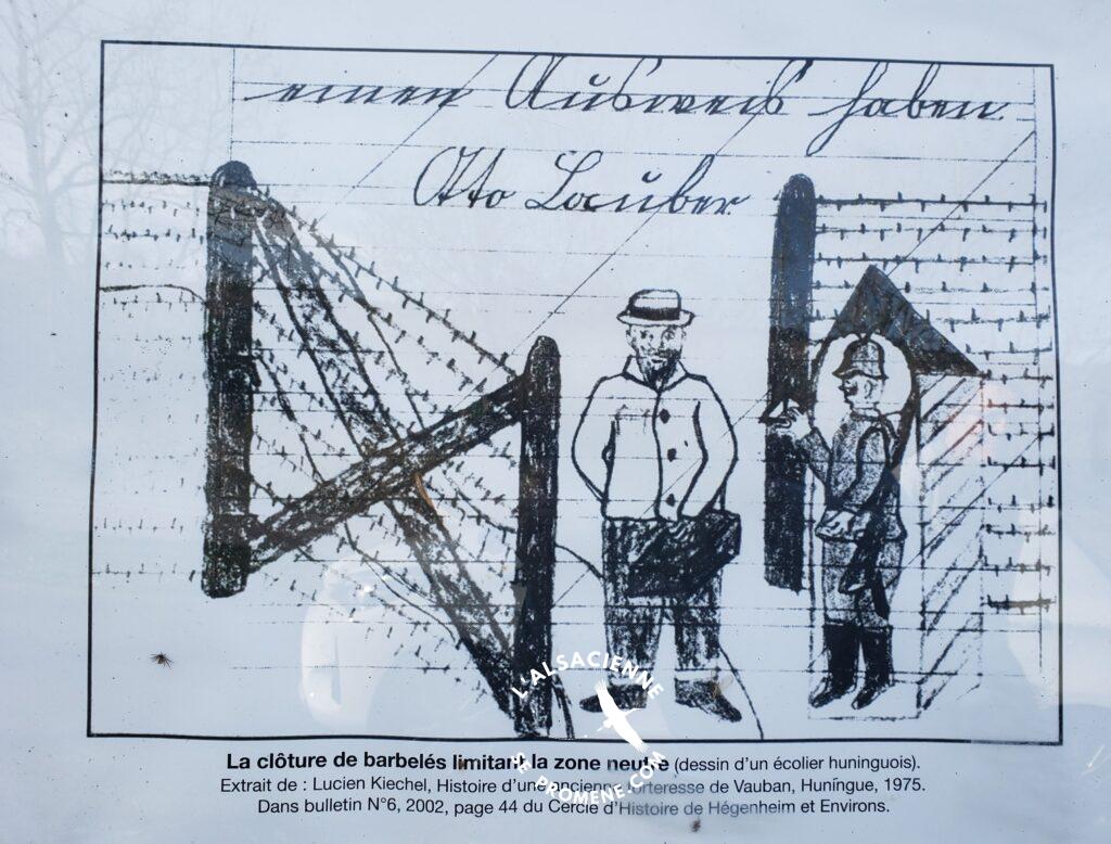 Dessin d'époque d'un écolier de HUNINGUE 68 représentant un point de passage avec guérite, au niveau de la barrière électrifiée du Haut Sundgau. Le franchissement est interdit aux civils. Il est autorisé avec laissez-passer aux fonctionnaires, prêtres, et sages-femmes. (Panneau explicatif route de WINCKEL 68)